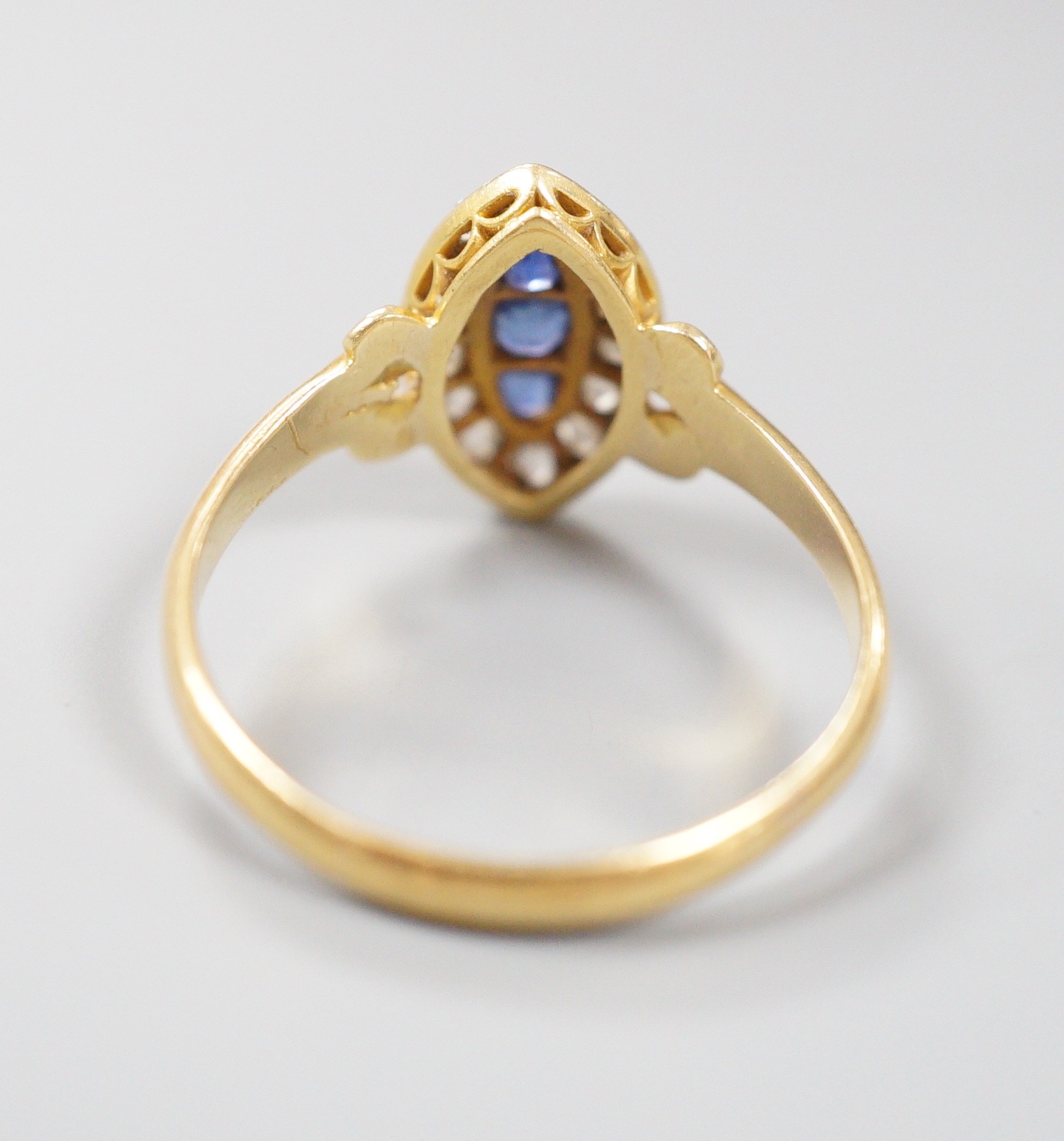 An early 20th century yellow metal, sapphire and diamond set marquise shaped cluster ring, with split shoulders, size R, gross weight 3.1 grams.